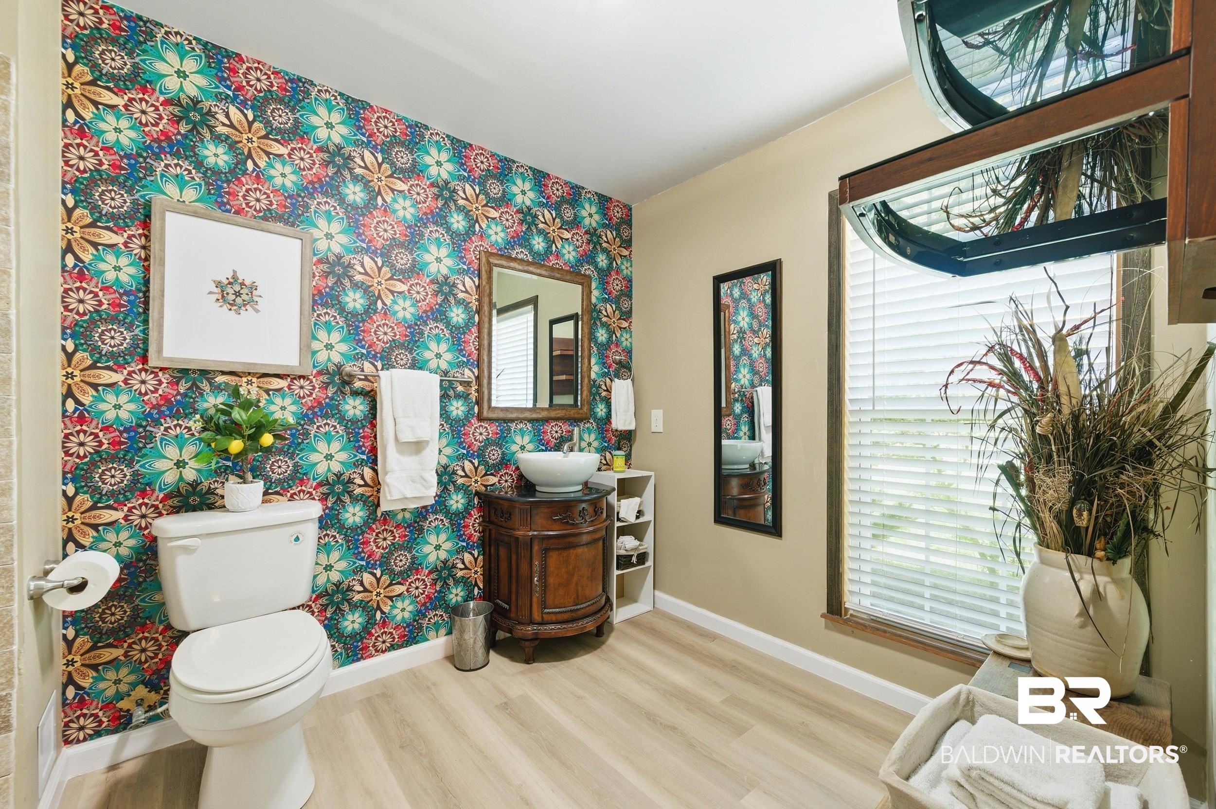 51620 Robert White Road Bay Minette, AL 36507 - Photo 14 of 81 Bathroom featuring an accent wall with floral wallpaper, a wood-finish vanity with a vessel sink, a toilet, and a window with horizontal blinds