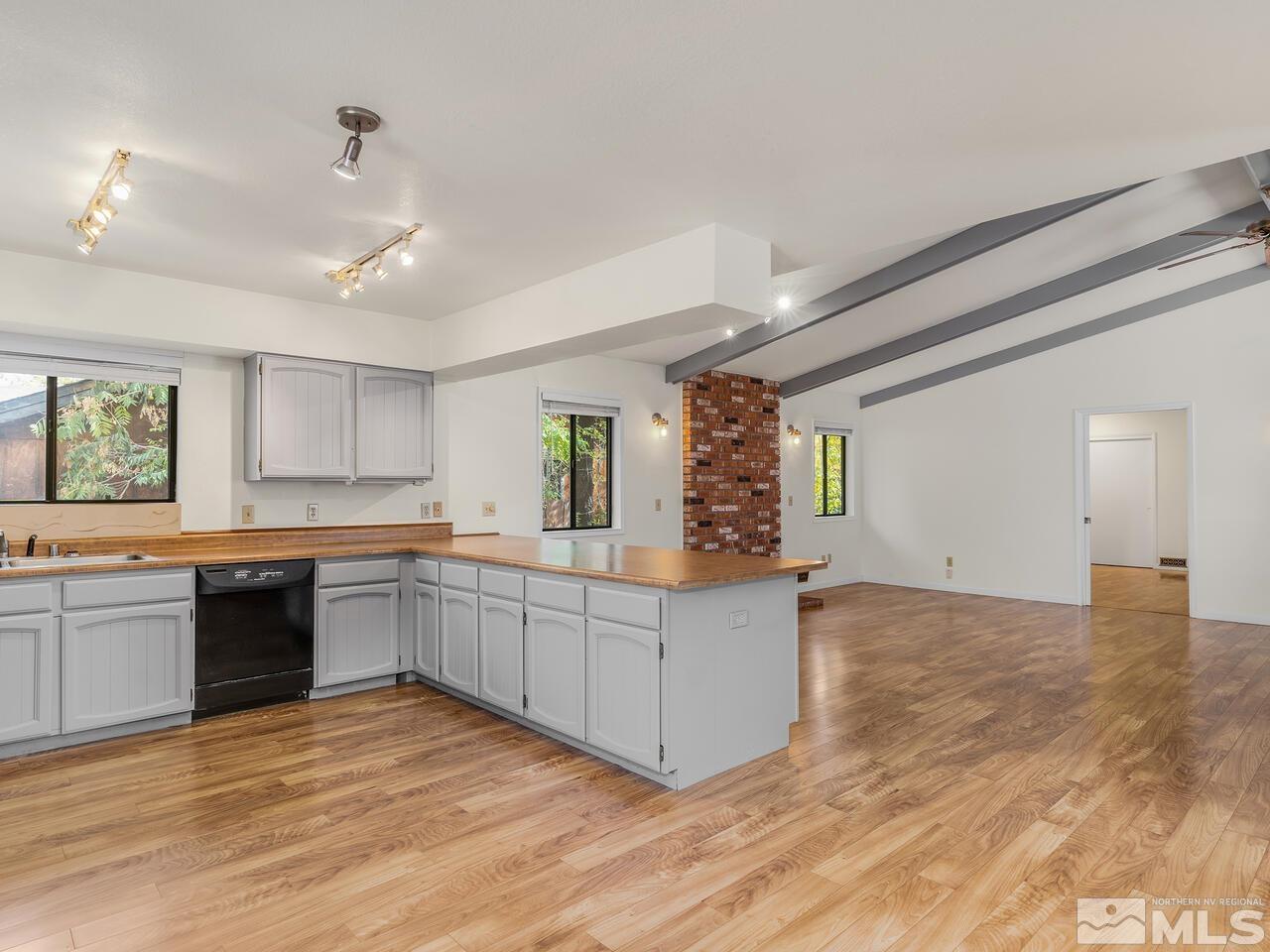 665 College Drive Reno, NV 89503 - Photo 11 of 25 a large kitchen with kitchen island a sink dishwasher a stove and a refrigerator with wooden floor