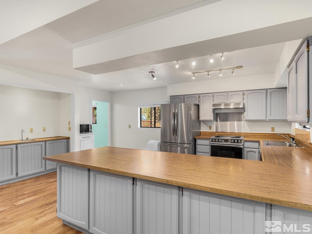 665 College Drive Reno, NV 89503 - Photo 10 of 25 a kitchen with stainless steel appliances granite countertop a lot of counter space and wooden floors