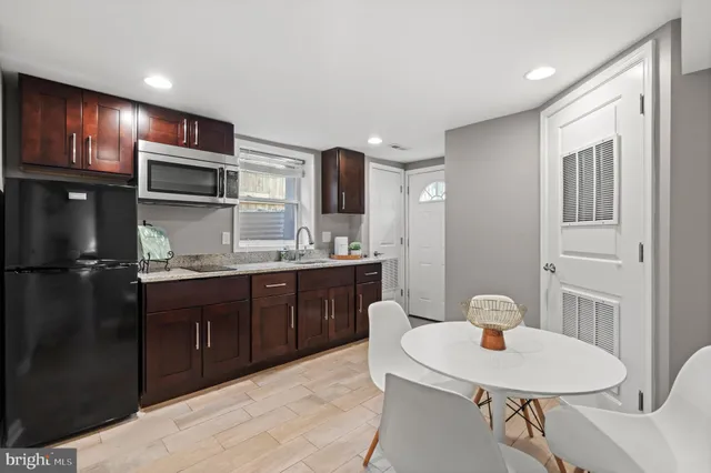a kitchen with stainless steel appliances granite countertop a sink refrigerator and cabinets