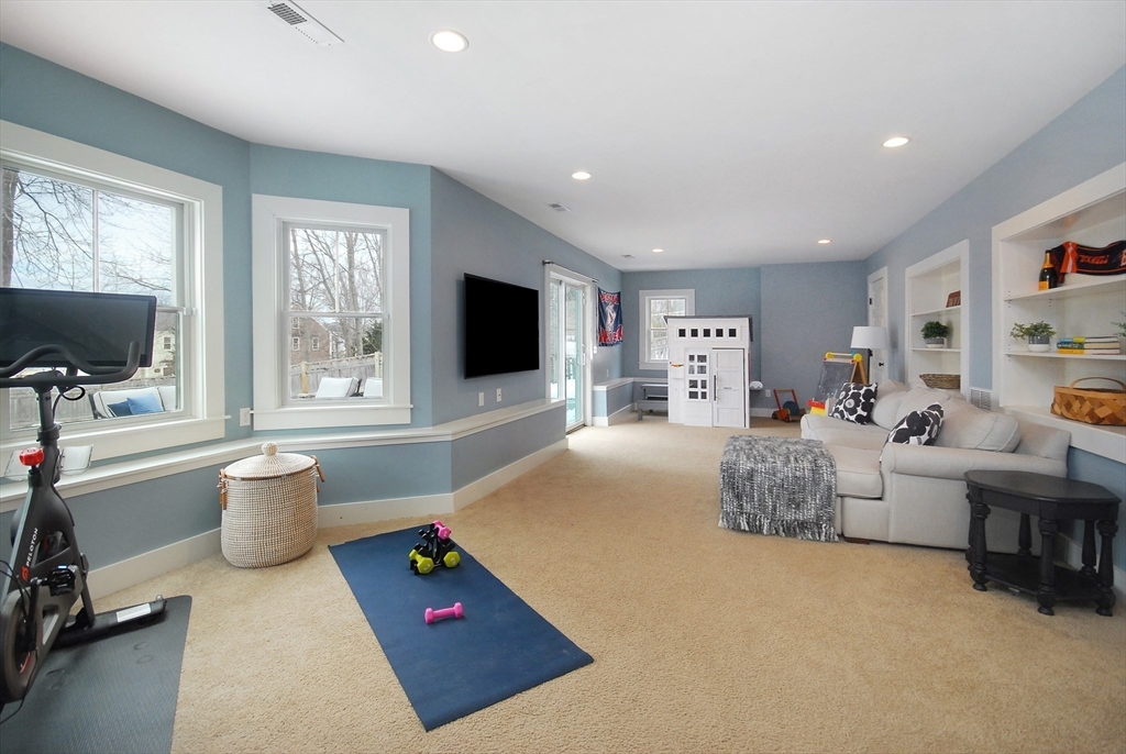 32 Highland Street Concord, MA 01742 - Photo 12 of 28 a living room with furniture a flat screen tv and a floor to ceiling window