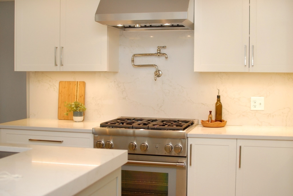 32 Highland Street Concord, MA 01742 - Photo 19 of 28 a kitchen with a stove and white cabinets