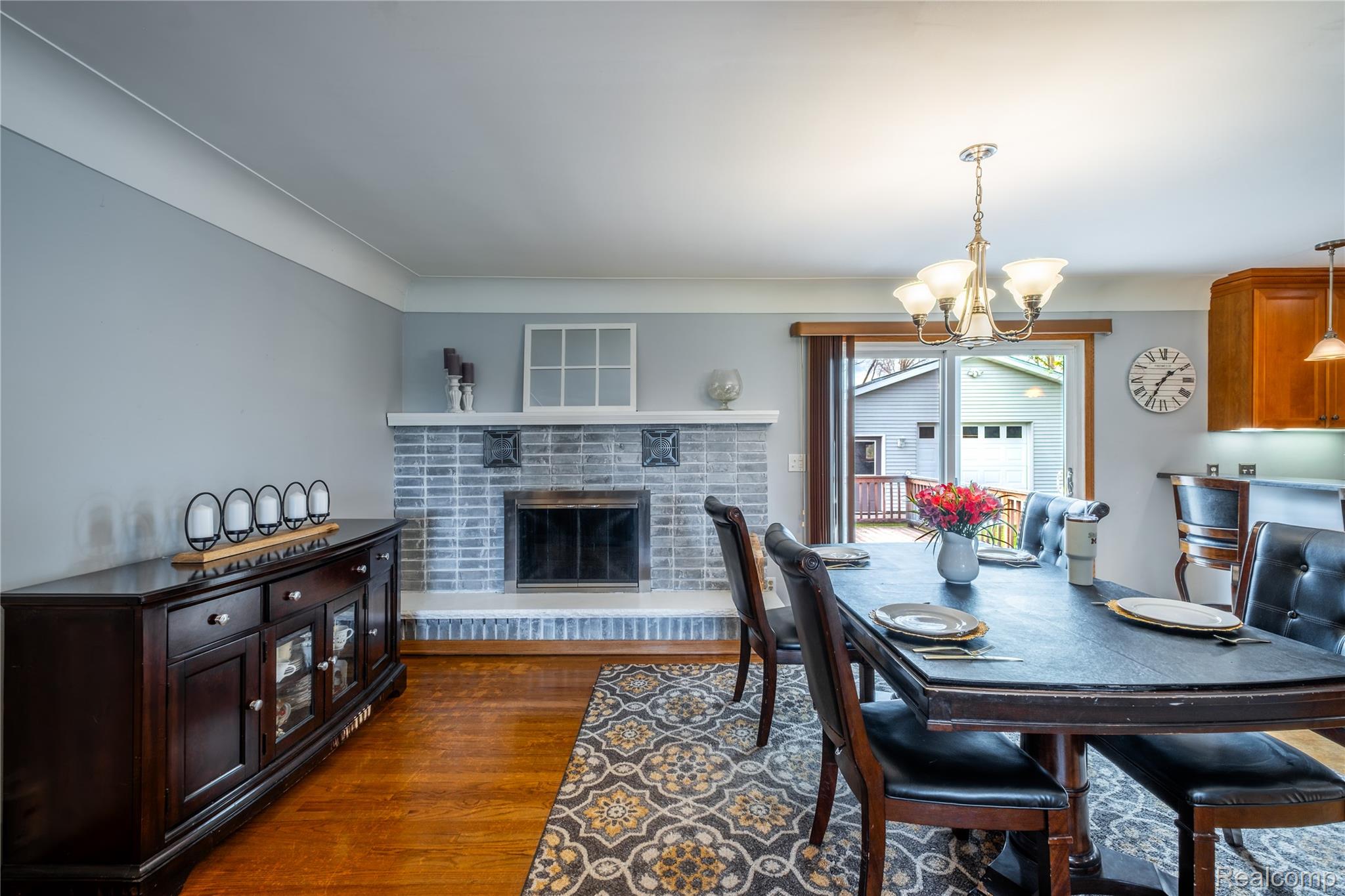 11430 Silver Lake Road Byron, MI 48418 - Photo 10 of 32 Dining area featuring a chandelier, dark wood-type flooring, and a fireplace