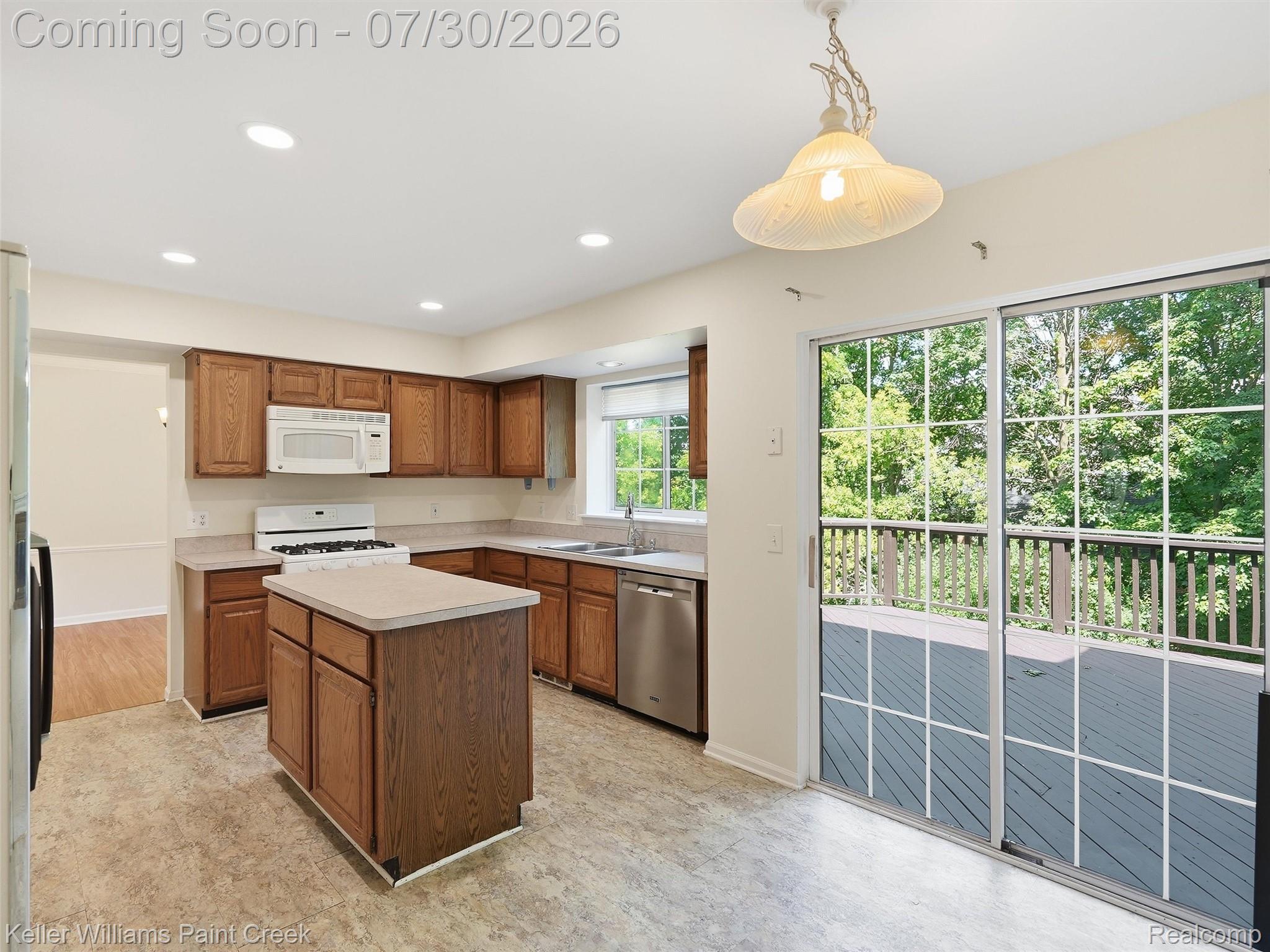 543 Arlington Drive Rochester, MI 48307 - Photo 12 of 59 Kitchen featuring wood cabinetry, a center island, recessed lighting, and a white gas range with an over-the-range microwave