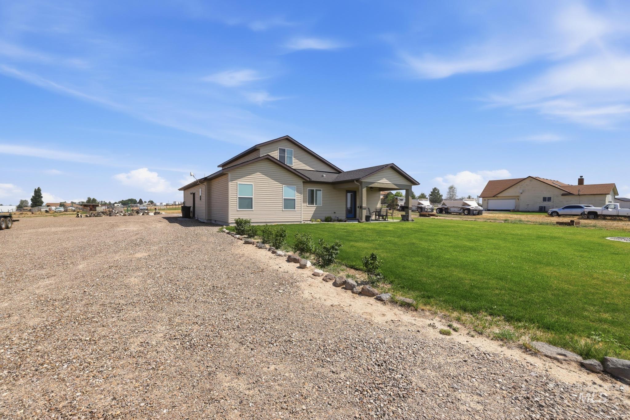 178 Syringa Loop Shoshone, ID 83352 - Photo 30 of 35 Two-story residence with a covered patio, set on a gravel lot with a green lawn