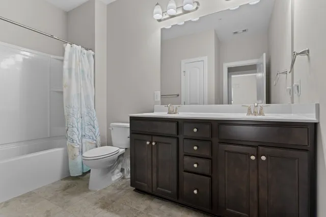 a bathroom with a sink vanity toilet and shower