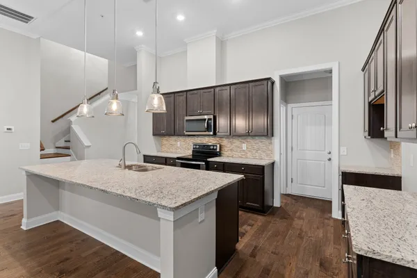 a kitchen with a sink refrigerator and microwave