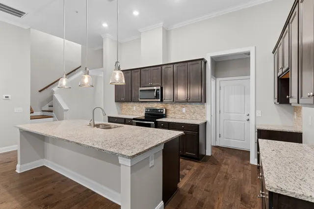 a kitchen with a sink refrigerator and microwave