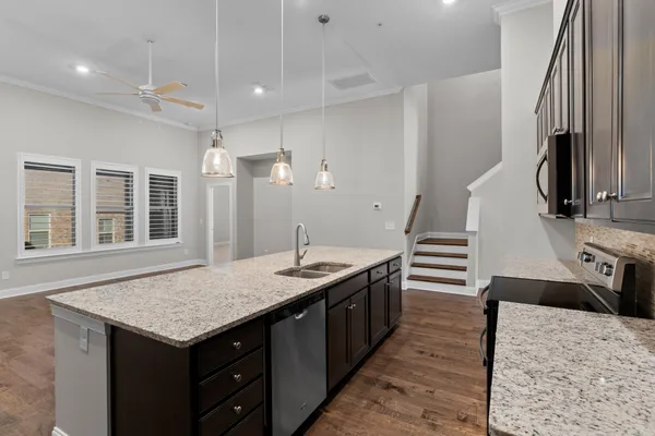 a kitchen with granite countertop a table chairs sink and stove