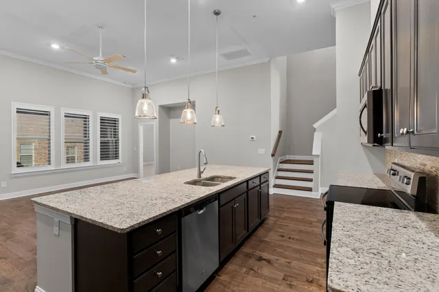 a kitchen with granite countertop a table chairs sink and stove