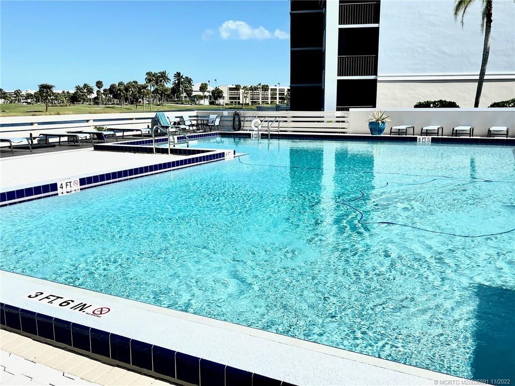 40 Northeast Plantation Road, Unit 208 Stuart, FL 34996 - Photo 18 of 38 a view of a swimming pool with a lawn chairs