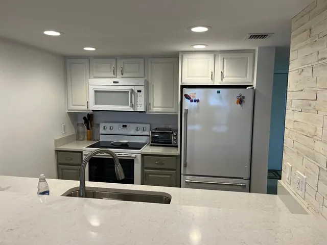 a kitchen with stainless steel appliances a refrigerator sink and stove