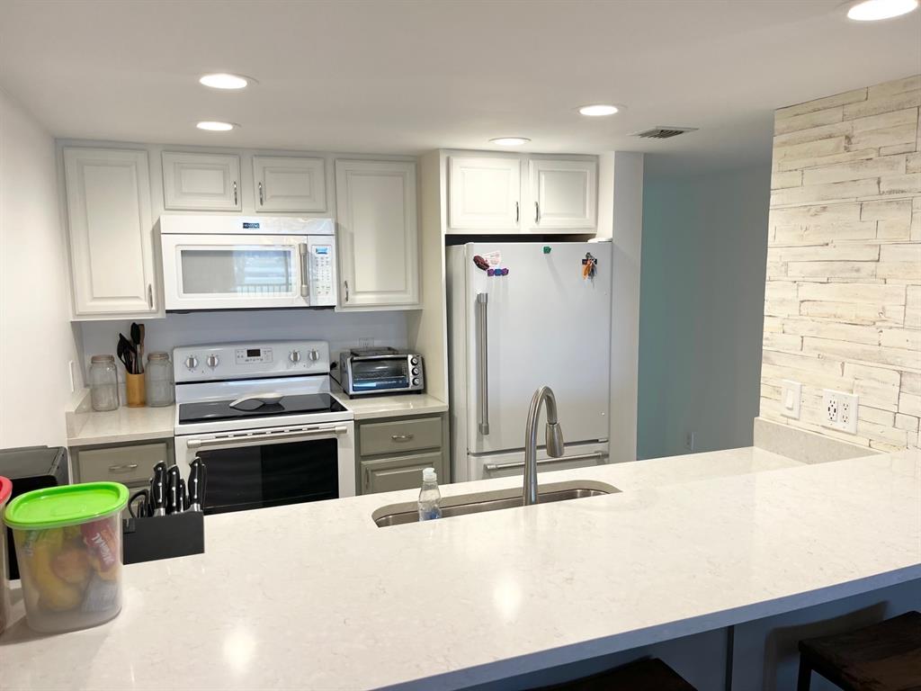 40 Northeast Plantation Road, Unit 208 Stuart, FL 34996 - Photo 23 of 38 a kitchen with stainless steel appliances a refrigerator sink and stove