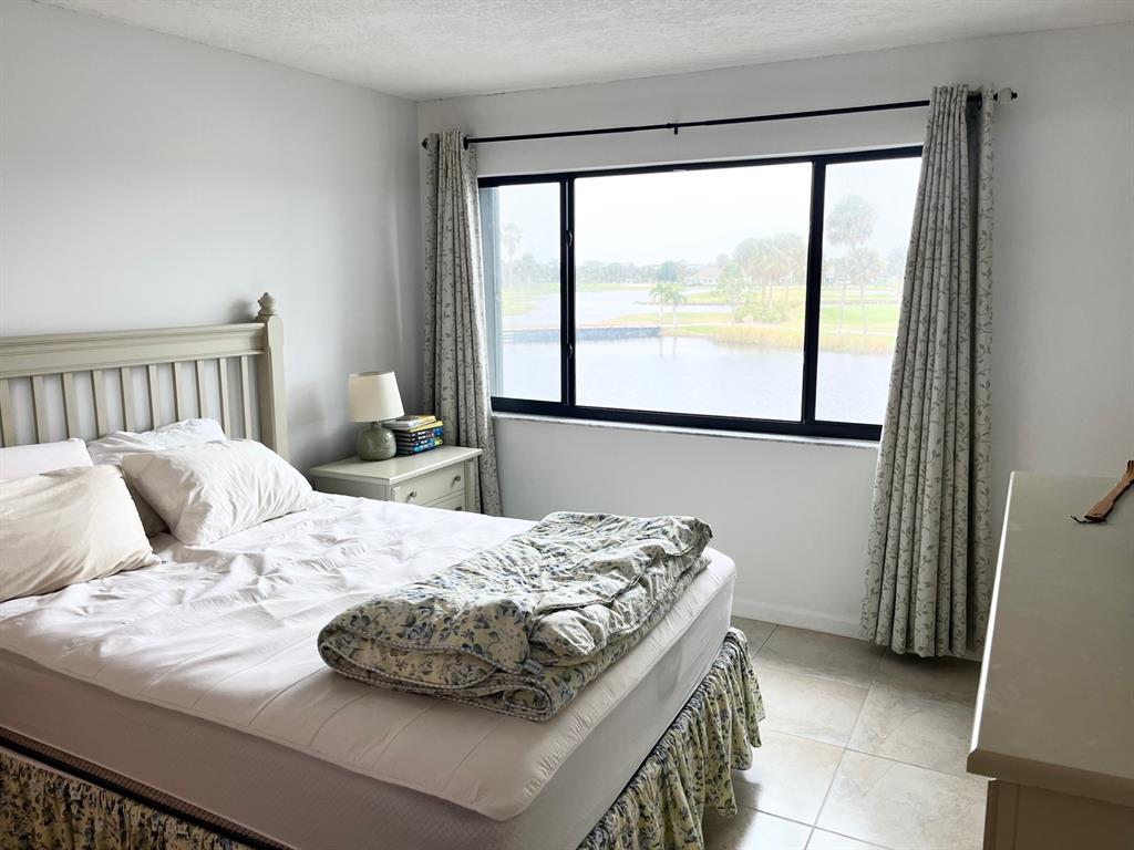 40 Northeast Plantation Road, Unit 208 Stuart, FL 34996 - Photo 3 of 38 a bedroom with a bed and a large window