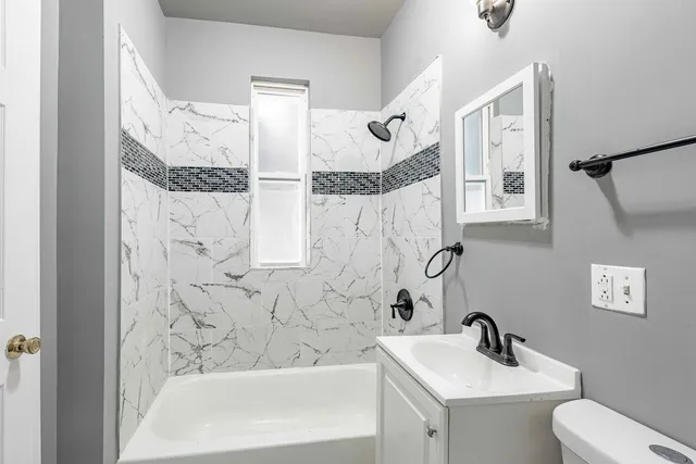a bathroom with a sink and mirror with bathtub