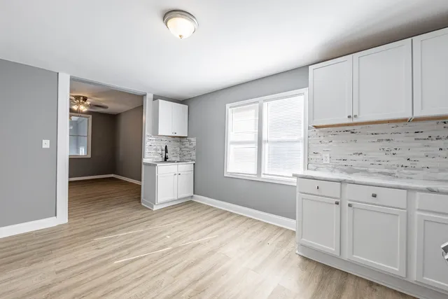 a kitchen with granite countertop white cabinets and white appliances