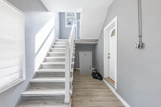 a view of a hallway with wooden floor and entryway