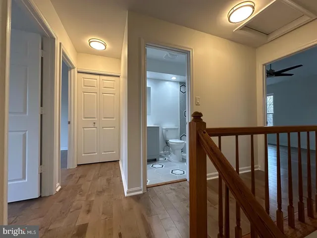 a view of a hallway with wooden floor and staircase