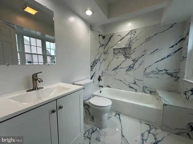 a bathroom with a sink toilet tub and shower
