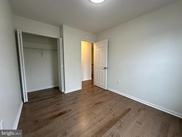 an empty room with wooden floor and closet