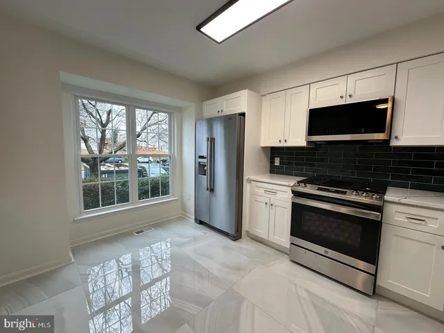 a kitchen with stainless steel appliances a stove a microwave and a sink