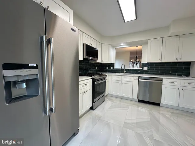 a kitchen with white cabinets and white appliances