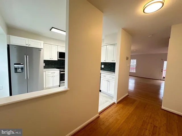 a view of a kitchen with a refrigerator and a stove top oven