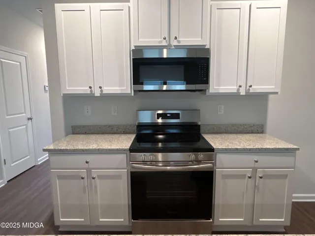 a kitchen with stainless steel appliances granite countertop a stove and a microwave