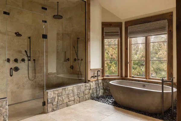 a bathroom with a large tub a shower and view