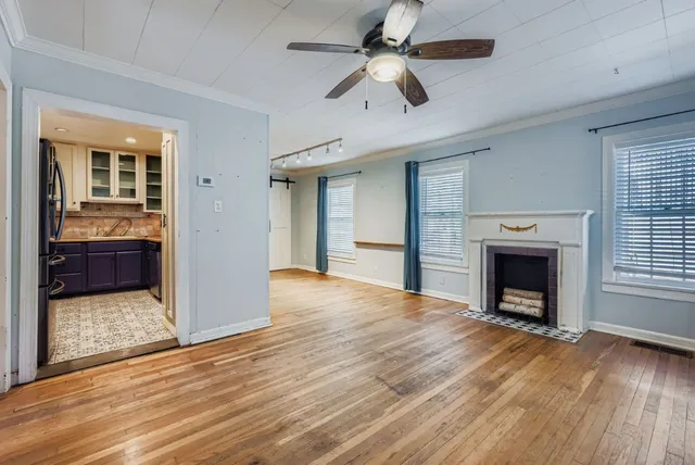 wooden floor fireplace and windows in an empty room