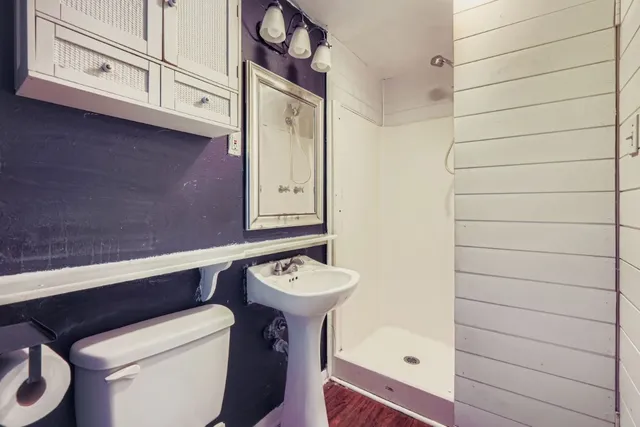 a bathroom with a toilet a sink and mirror