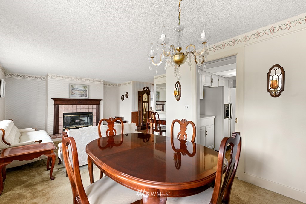 807 Union Street Northeast Renton, WA 98056 - Photo 15 of 38 a dining room with furniture a fireplace and chandelier