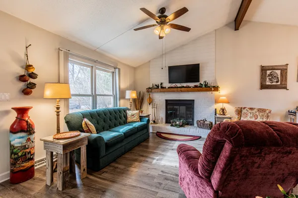 a living room with furniture a flat screen tv and a fireplace