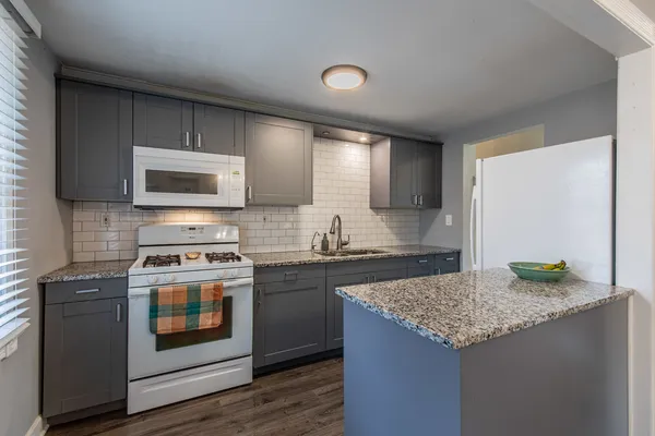 a kitchen with granite countertop a sink and a stove top oven