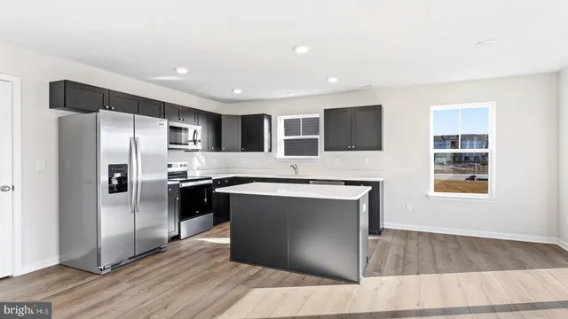 a kitchen with stainless steel appliances granite countertop a refrigerator a sink a stove and oven