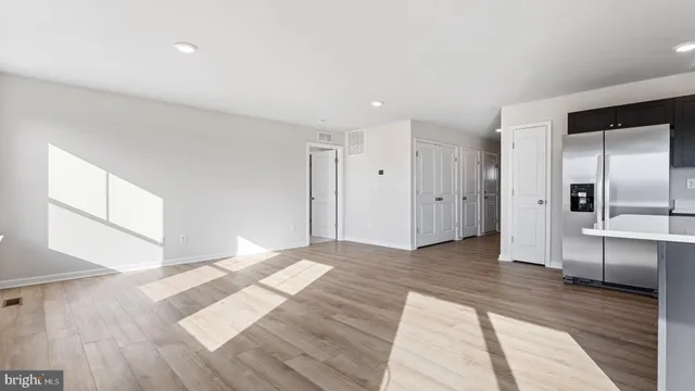 a view of empty room with wooden floor and window