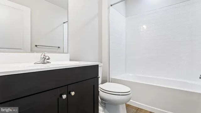 a bathroom with a sink vanity mirror and toilet