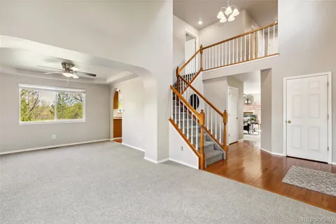 a dining room with furniture large windows and wooden floor