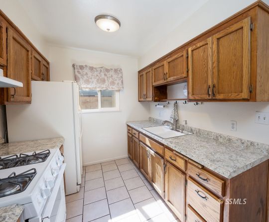 314 Lenore Street Ridgecrest, CA 93555 - Photo 13 of 29 a kitchen with a sink stove top oven and cabinets