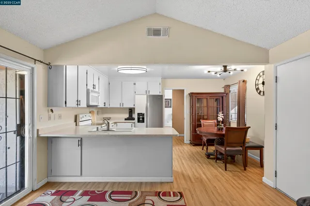 a living room with granite countertop furniture and a dining table with wooden floor