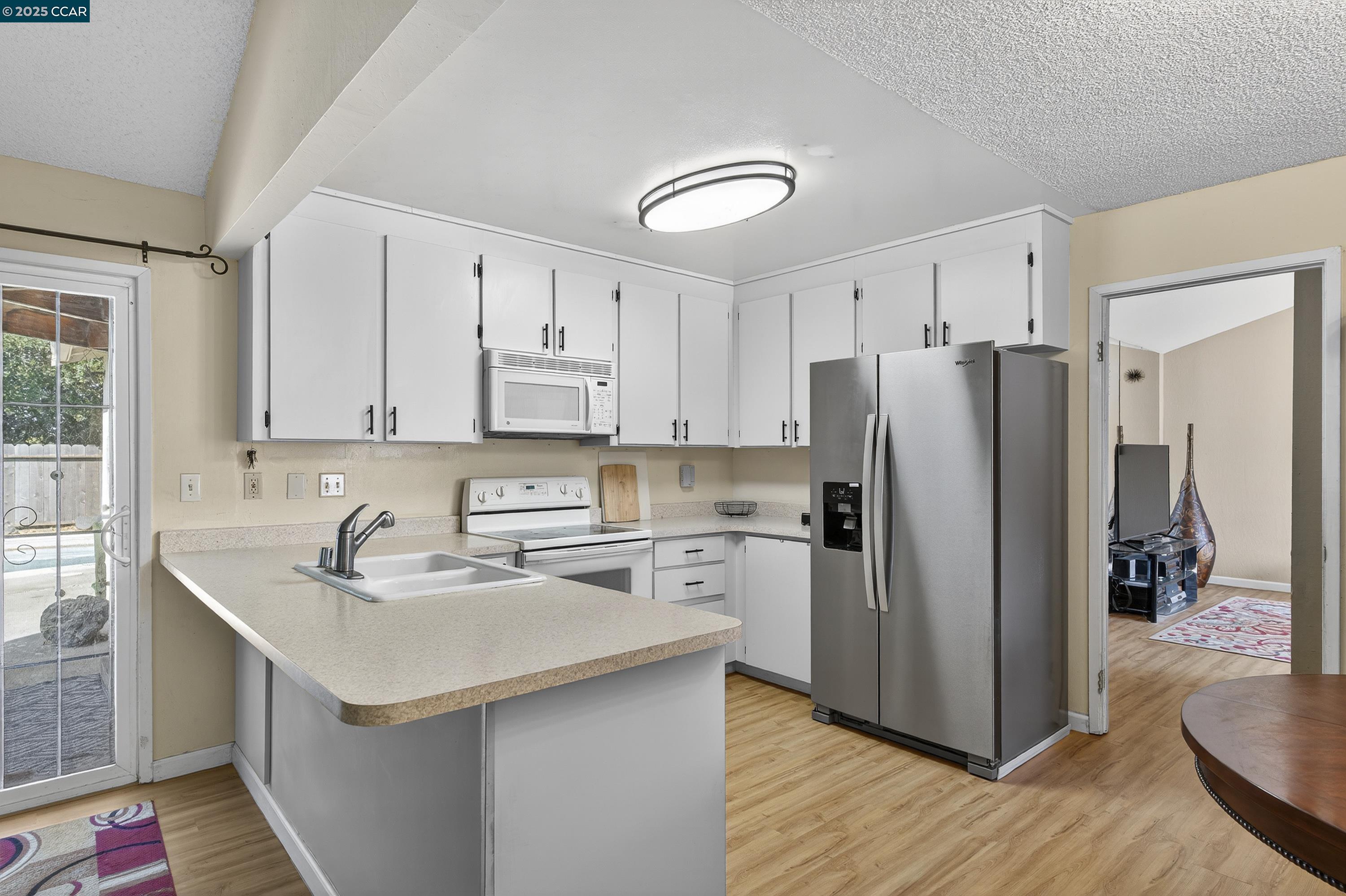 817 Ketch Court Rodeo, CA 94572 - Photo 12 of 45 a kitchen with a sink a refrigerator a microwave and cabinets