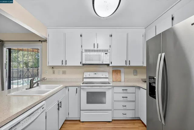 a kitchen with cabinets stainless steel appliances and a sink