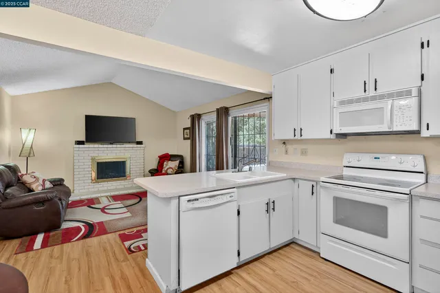 a kitchen with cabinets a sink and a stove with wooden floor