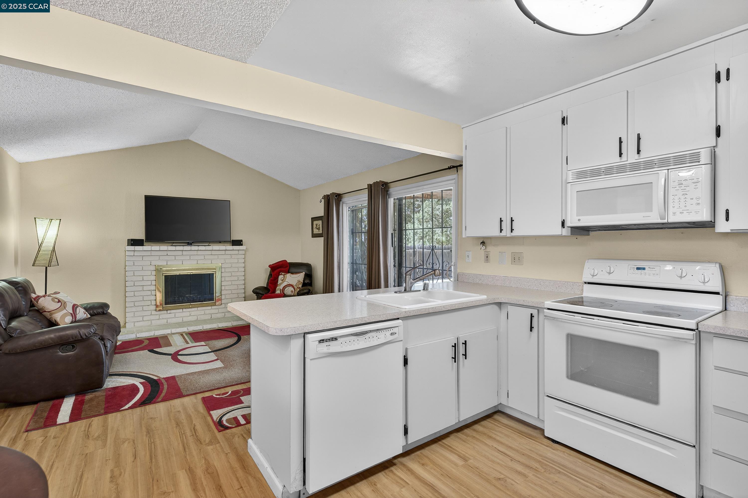 817 Ketch Court Rodeo, CA 94572 - Photo 14 of 45 a kitchen with cabinets a sink and a stove with wooden floor