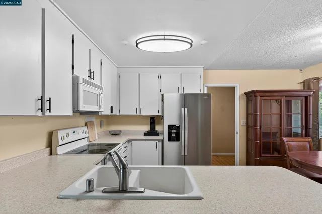 a kitchen with stainless steel appliances granite countertop a refrigerator sink and stove