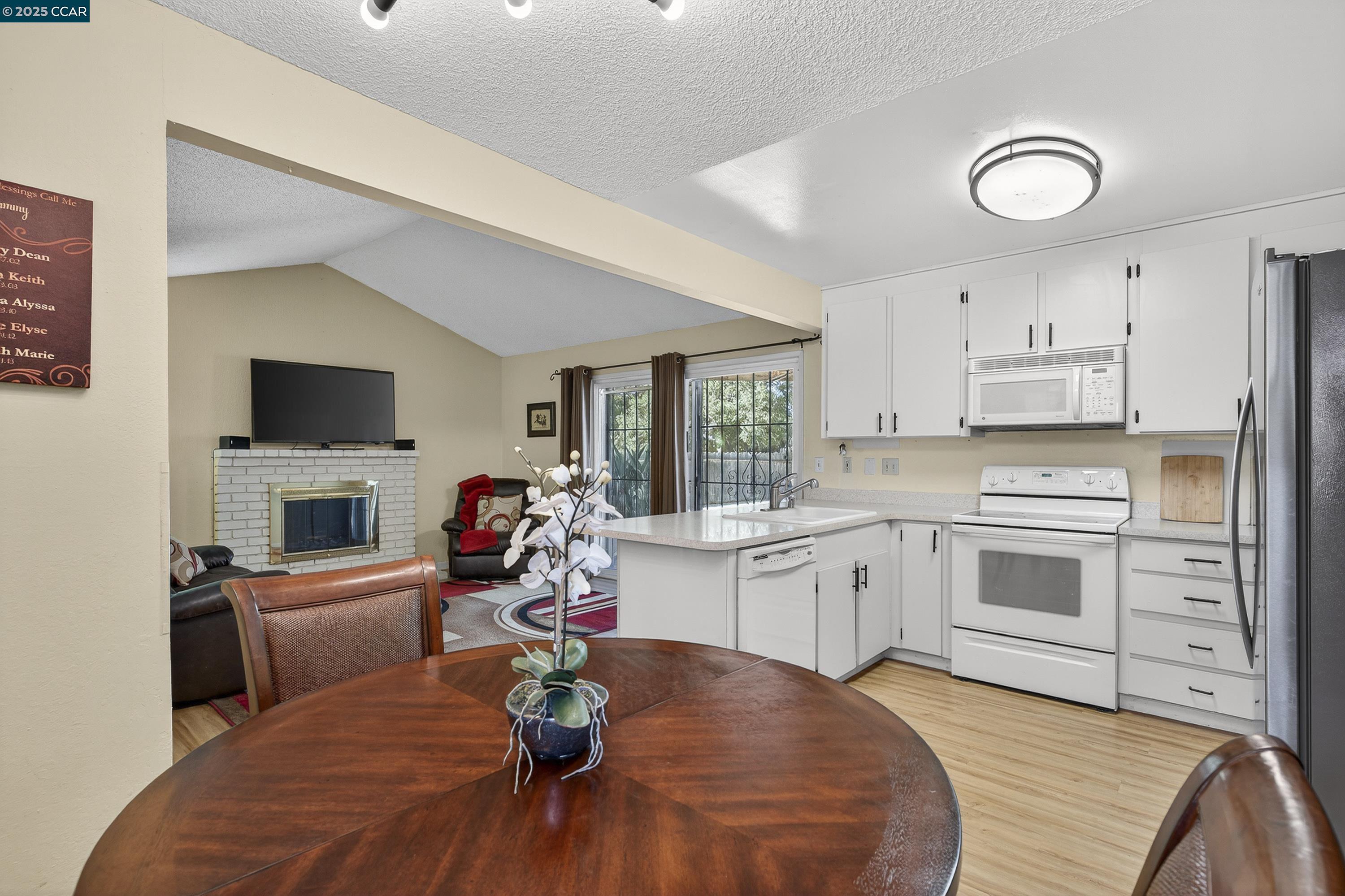 817 Ketch Court Rodeo, CA 94572 - Photo 17 of 45 a kitchen with a sink dishwasher stove and white cabinets with wooden floor