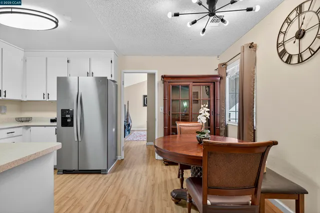 a kitchen with stainless steel appliances a dining table chairs and chandelier