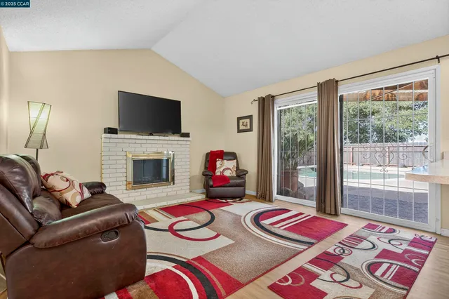 a living room with furniture a flat screen tv and a fireplace
