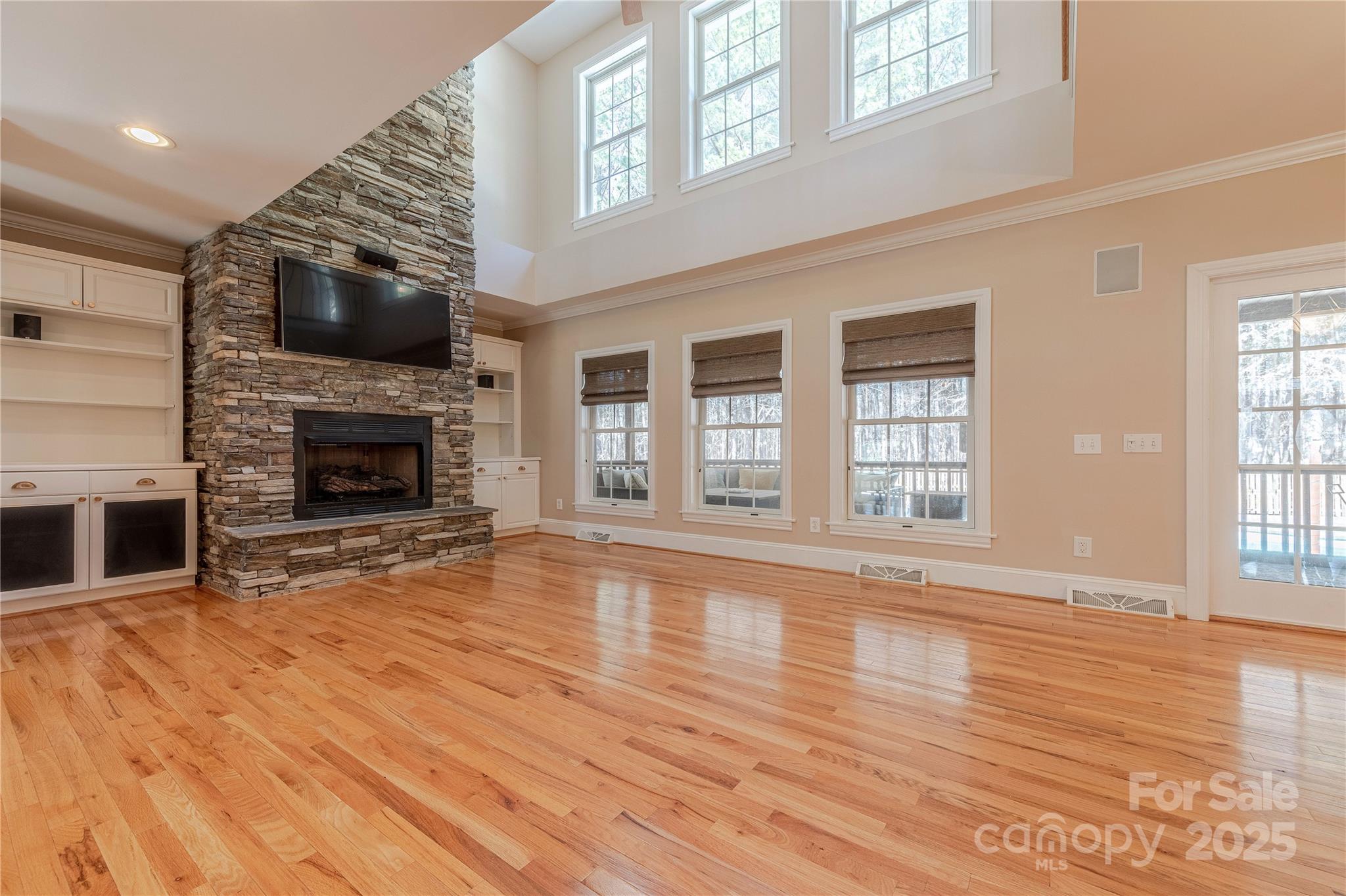 2174 McKee Road Fort Mill, SC 29708 - Photo 13 of 48 an empty room with wooden floor fireplace and windows