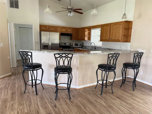 a kitchen with stainless steel appliances granite countertop a kitchen island hardwood floor sink and stove